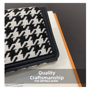 Detailed view of black and white houndstooth fabric with premium stitching and leather trim