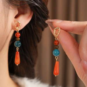 Detailaufnahme von Boho-Ohrhängern mit bunten Perlen und goldenen strukturierten Steckern