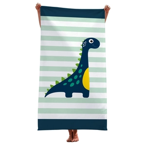 Detail of soft beach towel with blue stripes and a cute cartoon dinosaur illustration