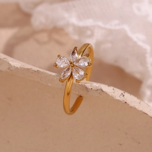 Macro shot of gold-plated five-petal flower ring with micro-set zircon on white lace