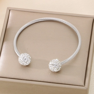 Macro shot of silver twisted cable bangle featuring two crystal-pave spheres at ends