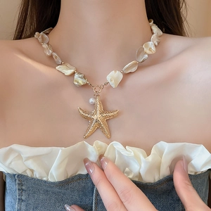 Detail of starfish pendant necklace with irregular shell beads and a small pearl accent