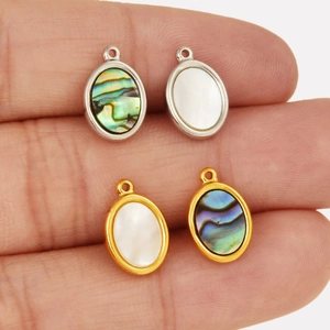 Détail de pendentifs ovales en acier inoxydable avec nacre et ormeau incrustés