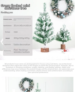 Close-up of green flocked mini Christmas tree with snow effect on a rustic wood base
