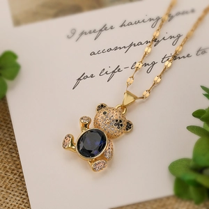 Macro shot of gold plated teddy bear pendant with blue stone and zircon micro-paving