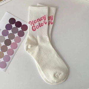 Dettaglio di calzini in cotone bianco con ricamo rosa Honey Color e polsini elastici