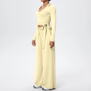 Détail du haut cache-coeur crème et du pantalon large à taille haute sur modèle