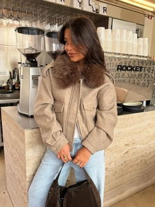 Close-up of khaki short wool jacket with plush brown faux fur collar and zip pockets