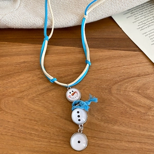 Détail du pendentif bonhomme de neige avec écharpe bleue sur cordon en suédine