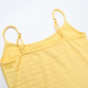Detail of yellow ribbed knit texture and spaghetti straps on backless mini dress