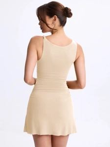 Vue détaillée du dos d'une robe sans manches beige ajustée avec des fronces à la taille