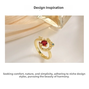 Macro detail of gold ring with red gemstone and moon-star design on satin backdrop