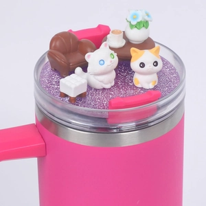 Detail of 40oz pink tumbler lid featuring miniature cats on a sofa with purple glitter