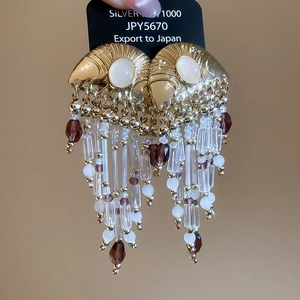 Detail of vintage gold fan tassel earrings with white pearls and purple crystal beads