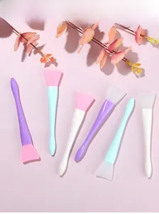 Flat lay of professional silicone facial mask brushes in various soft Morandi color tones