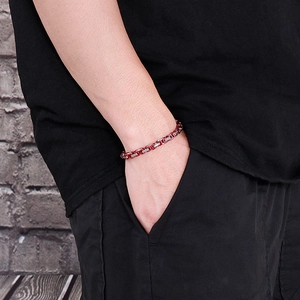 Detail of red and silver stainless steel chain bracelet worn on a man's wrist