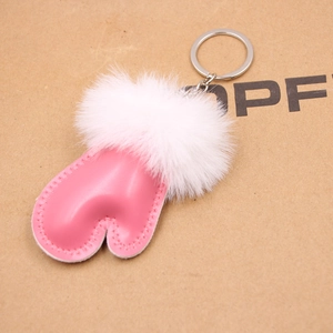 Detailed view of a pink leather winter mitten keychain with white faux fur and silver ring