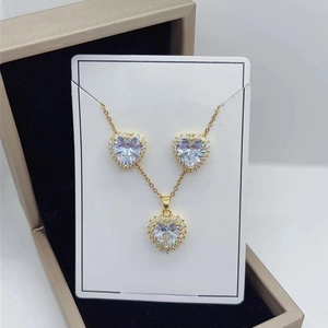 Detail of heart-shaped zircon necklace and earrings set in gold finish jewelry box