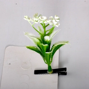 Macro detail of artificial sprout hair clip with small white flowers on black clip