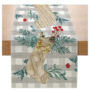 Detailed view of linen Christmas table runner with festive pine cones and holly patterns