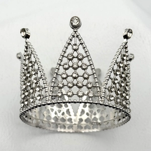 Macro detail of silver alloy crown cake topper with sparkling crystals and lattice design
