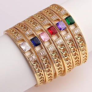 Detail of colorful rectangular zircon stone bangles with gold chain link textures