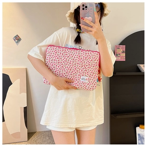 Detailed view of pink floral laptop sleeve with HELLO label and zipper closure