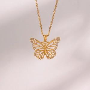 Detail of gold hollow butterfly pendant necklace with inlaid white cubic zirconia stones