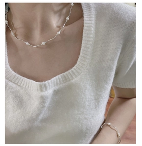 Detail of silver bar and freshwater pearl necklace with matching bracelet on model