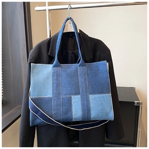 Detail of color-block denim tote bag showing fabric texture and adjustable shoulder strap