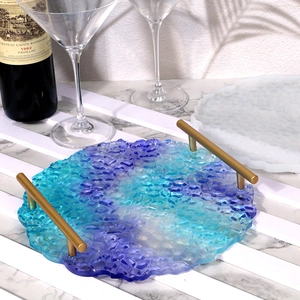 Close-up of DIY resin jewelry tray with irregular round shape and gold metal handles