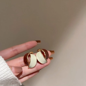 Detailed shot of vintage red and white geometric enamel heart earrings with gold trim