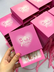 Detalle del empaque rosa de uñas postizas con corazón y marcas de tallas XS a L