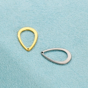 Pendentifs minimalistes goutte d'eau or et argent sur fond bleu texturé