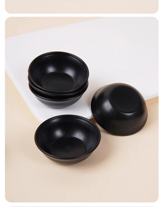 Detailed view of matte black miniature sauce dishes in various stacking positions