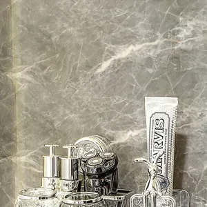 Dettaglio del dispenser di sapone in vetro e del bicchiere in un telaio argentato