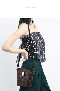 Detail of vintage bucket bag with contrast monogram print and golden metal magnetic closure