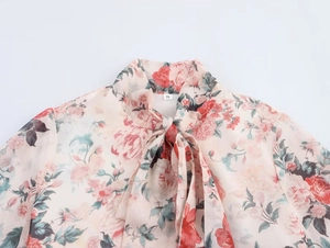 Detailed view of the tied neckline and floral chiffon fabric on this pink S-size top