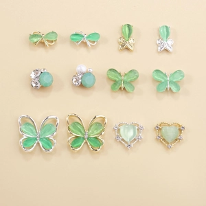 Detail view of cat eye butterfly nail art charms with mint green stones and crystals