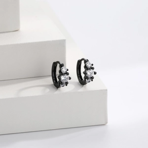 Macro shot of black sterling silver earrings with three white cubic zirconia stones