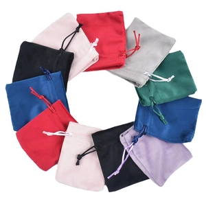 Velvet drawstring jewelry pouches in multiple vibrant colors arranged in a circle
