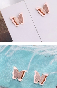Detail of rose gold butterfly earrings with frosted texture and dual-layer design