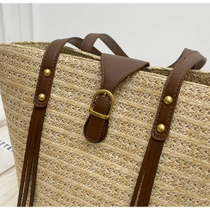 Close-up of woven straw texture with brown leather strap and gold metal buckle detail