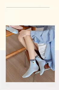 Detail showing blue cotton socks with cute dog embroidery and striped knit texture