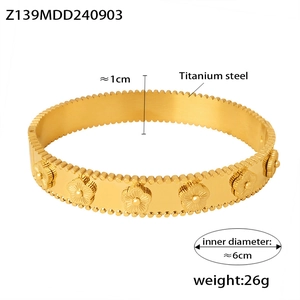 Dettaglio del bracciale rigido in titanio placcato oro 18k con rilievo floreale