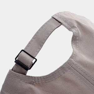 Close-up of adjustable strap and stitching on beige cotton embroidery baseball cap