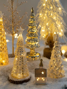 Macro shot of glass Christmas trees with LED lights and wooden base for home decor