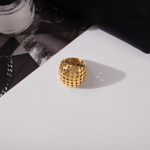 Détail d'une bague sphérique creuse en or 18 carats avec texture à écailles moderne