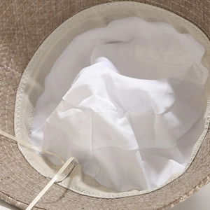 Detail of breathable linen texture, soft inner lining and adjustable drawstring on sun hat