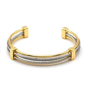 Two-tone woven stainless steel cable open bangle with gold accents in minimalist design